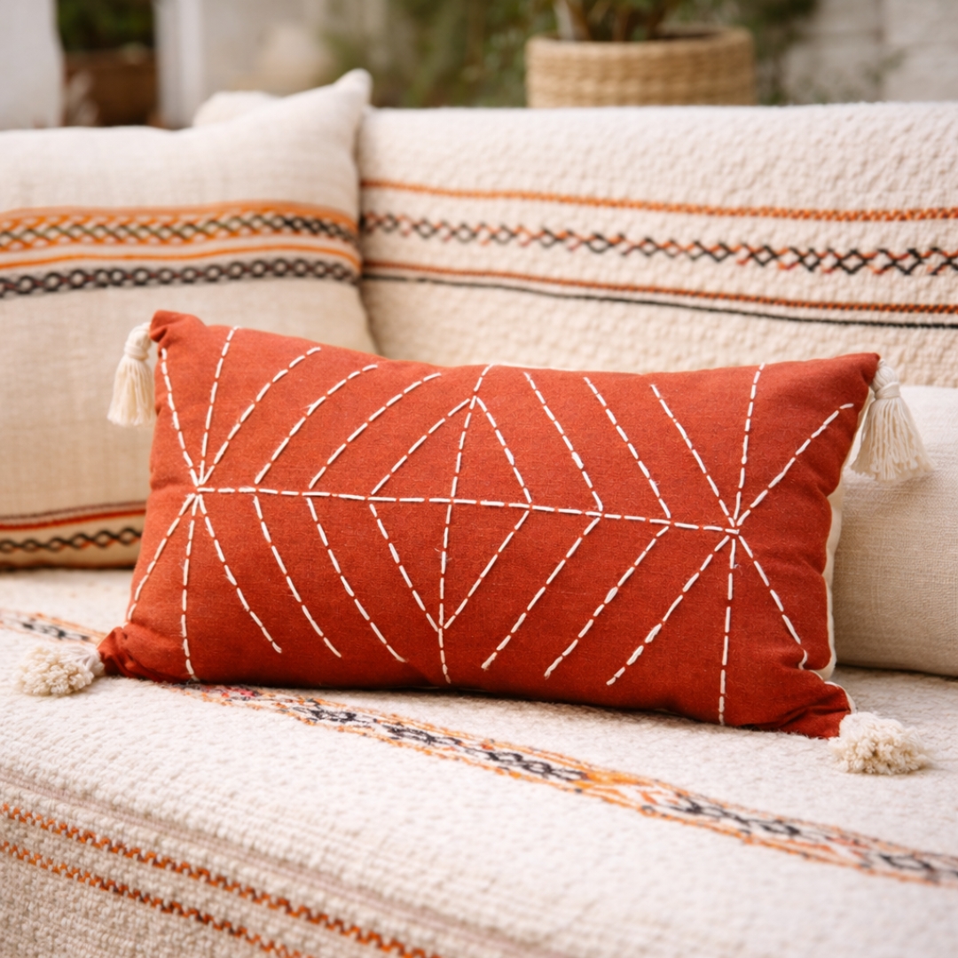 coussin rouge brique brodé à la main avec pompons en coton style artisanal